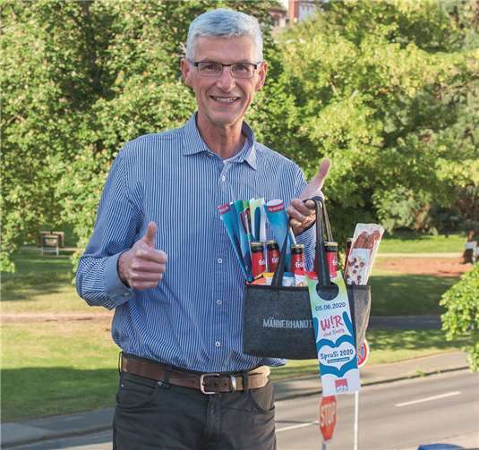 Reiner Friedsam, Vorsitzender der Aktivgemeinschaft, präsentiert die Männerhandtasche. Foto: Friedsam Werbeagentur