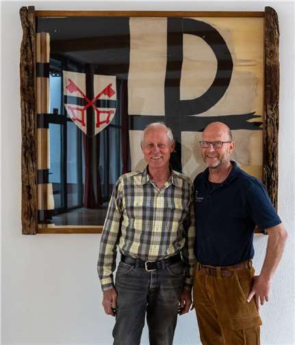 Reinhard Helf und Joa Helf (rechts) präsentieren das alte Banner des Zeltlagers im neuen, uralten Rahmen. Foto: privat