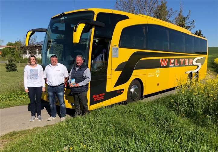 Reisebusfahrer Wolfgang von Werder und Geschäftsführerin Nicole Reinart überreichten Walter Pies zur Reise noch einen Reiseführer. Foto: Welter’s Reisen
