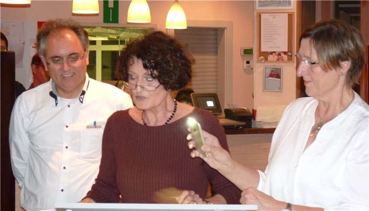 Renate Köpke erklärt die Regionalküchen Chinas, assistiert von Brigitte Kuchta mit Handy-Lampe.
