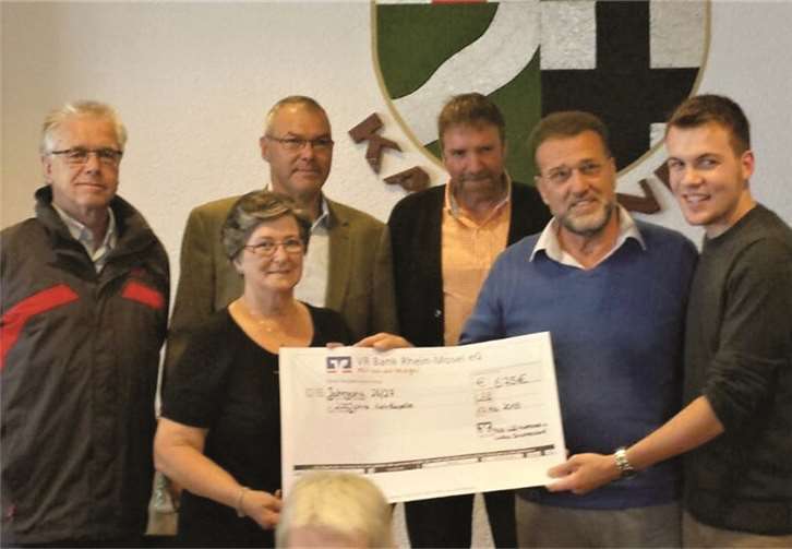 Renate Lellmann, Vorsitzende des Pfarrgemeinderates, und Lukas Brachtendorf überreichten Mitgliedern des „Freundeskreises Jahrgang 26/27“ symbolisch den Erlös des Kapellenfestes.privat