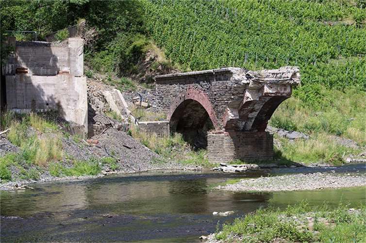 Reste einer zerstörten historischen Brücke nach der Flutkatastrophe im Ahrtal.  Foto: Landtag RLP