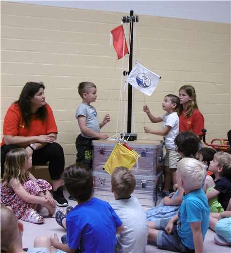 Rettungsschwimmerinnen und die Kita-Kinder beschäftigen sich spielerisch mit den Baderegeln und den Aufgaben der DLRG. Foto: Stadt Meckenheim
