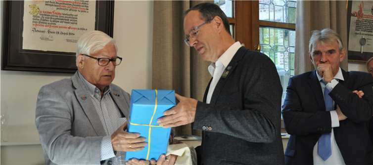 Richard Welter überreicht ein Präsent zum Dank an Bruno Peeters. Im Hintergrund ist die Urkunde des 25-jährigen Jubiläums von 2004 zu sehen. Foto: Mia Hoeykens, Ekeren