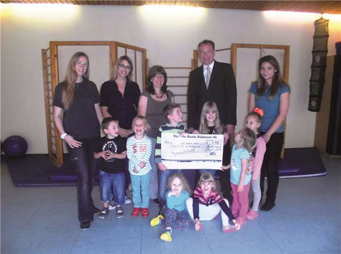 Rita Scharnbach (KiTa-Leiterin, 3. v.l.) und Henning Oster (Leiter Filialvertrieb der Sparda-Bank Südwest in Andernach) und das Kindergarten-Team mit einigen Kindern der KiTa St. Hildegard. Privat