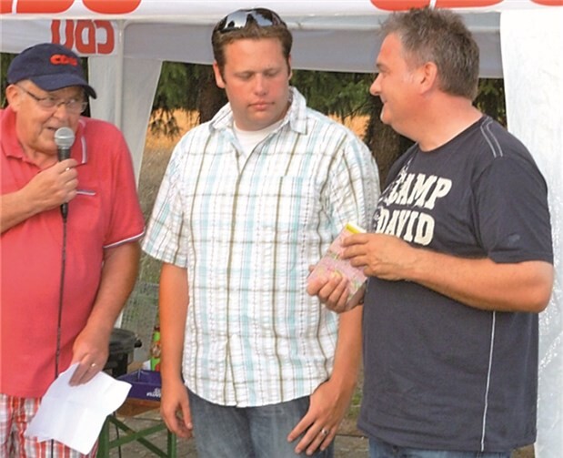 Robert Castor (l.) und Lars Hansen gratulieren Mario Ihrlich, dem Sieger des Gewinnspiels (r.).
