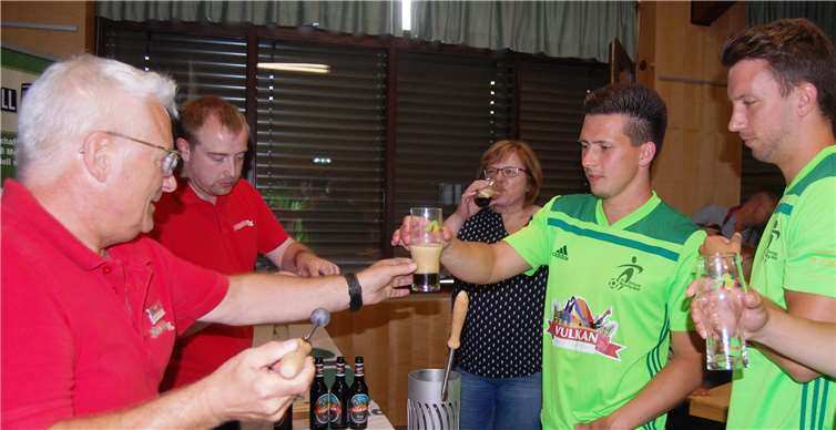 Robert Kamm (l.) und Sebastian Kaiser überreichten bei der Bierverkostung ein gestacheltes Bier an Björn Gilles und Manuel Oster (r.). Beim Bierstacheln wird ein glühender Metallstab in eiskaltes Bier getaucht.