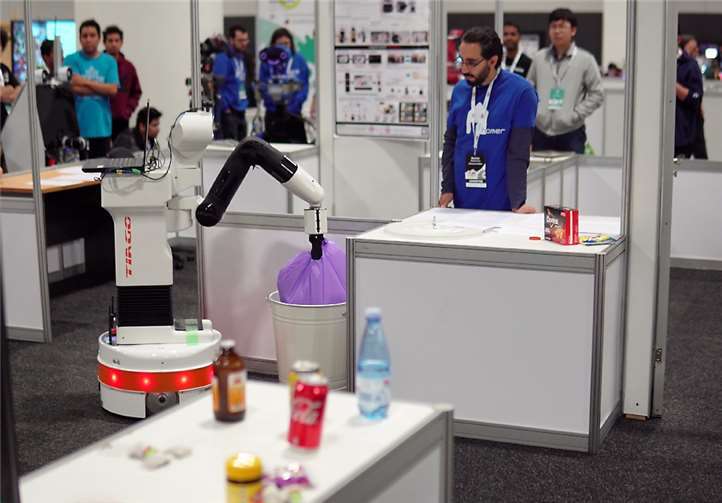 Roboter TIAGo beim Robocup 2019 in Sydney hebt einen Müllsack aus dem Mülleimer und bringt ihn nach draußen.