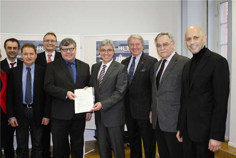 Roger Lewentz (Mitte r.) übergibt Verbandsbürgermeister Michael Mahlert (Mitte l.) den Bewilligungsbescheid.