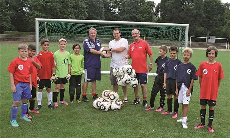 Roland Fergen (links) und Dieter Finkler (rechts) übergeben der D-Jugend zwanzig Spielbälle für die neue Saison.-th-