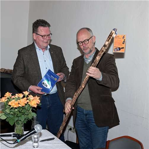 Rolf Schlipköter überreicht einen Spazierstock mit Whisky-Füllung (Idee des „Whisky-Wanderstocks“ von Helmut Koch, Adenau) an den Krimiautor.