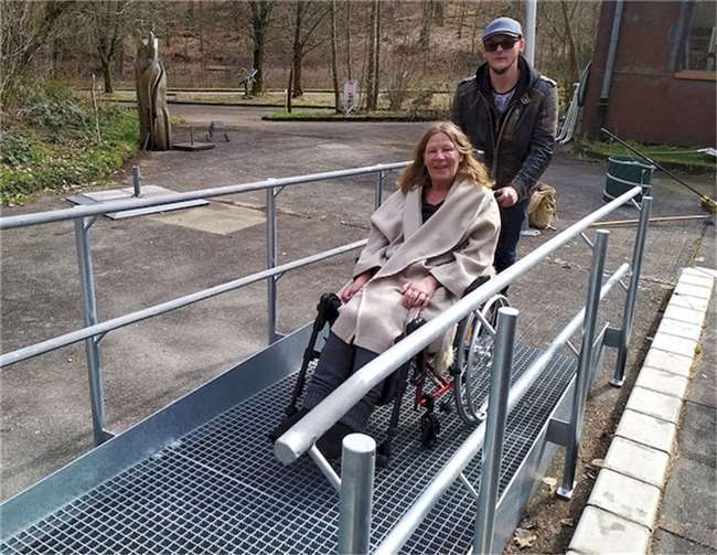 Rollstuhlfahrerin Jutta Brast freut sich über die neue Rampe am Podest des Außenbereichs am b-05-Café. Foto: Herbert A. Eberth