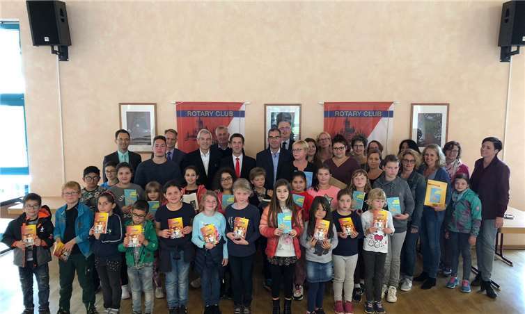 Rotarier, Sponsoren, Lehrerinnen + Schüler mit den Büchern des Leseprojektes LLLL.Foto: Rotary Club
