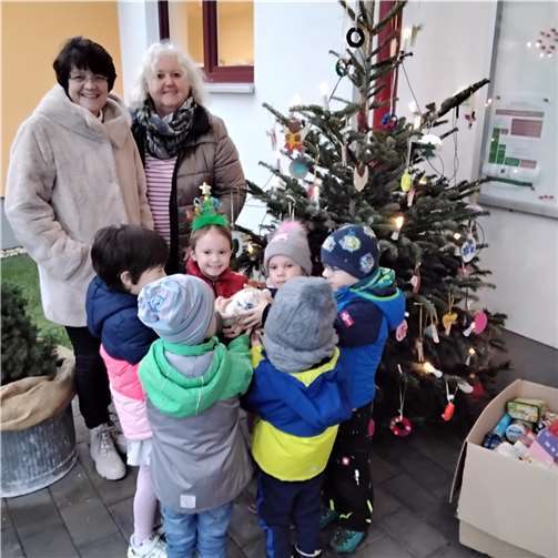 Ruth Evers und Petra Endres, pädagogische Fachkraft, mit den Kindern der KiTa St. Martin, Ochtendung bei der Übergabe der Spenden.  Foto: Dietmar Barth