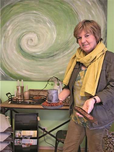 Ruth Lehnen mit selbst angefertigten Stücken aus Naturmaterialien. Bei ihren Kunstwerken in Acryltechnik (im Hintergrund) bevorzugt sie Abstraktes. BÜN