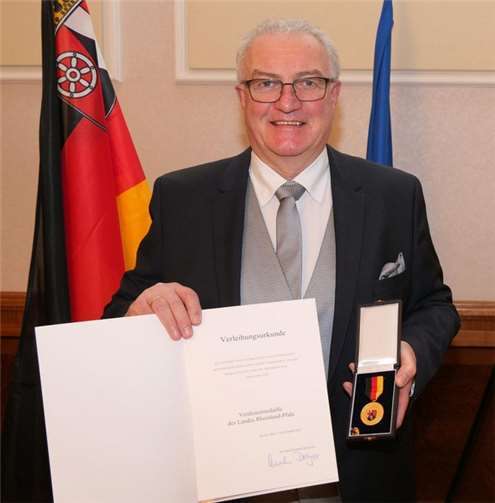SGD-Nord-Präsident Uwe Hüser mit der Urkunde sowie der Verdienstmedaille für Kurt Sahm. Foto: Kurt Sahm