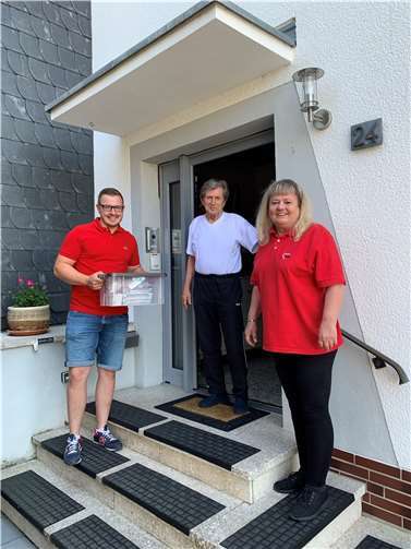 SPD-Bürgermeisterkandidat Dominik Pretz (links) und AWO-Helferin Petra Holit (rechts) bei der Essensübergabe an Herrn Link (Mitte) in Weitersburg.  Foto: SPD-VG Vallendar