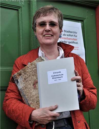 Sabine Post mit dem Original und dem Ausdruck der Schulchronik Rheinbach.