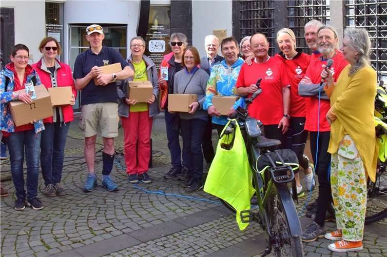 Sabine Schmitz (1. v.r.) nimmt zusammen mit Vertretern anderer Weltläden die Schokolade der Schokoradler Norbert Dümpelfeld (2. v.r.) Peter Schmitz (3. v.r.), Bettina Anedda (4. v.r.) und Karl-Heinz Weingart (5. v.r.) entgegen. Foto: Karl-Peter Schmelzeisen