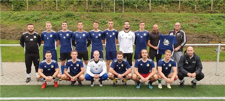 Saleh El-Bayyari (stehend 2. v.r.) bei der Übergabe der Shirts an Abteilungsleiter Christian Müller (stehend rechts). Foto: Rolf Schmitt