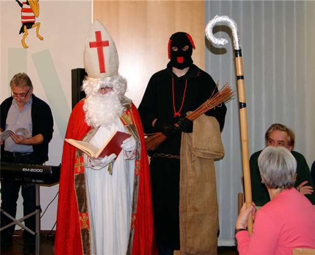 Sankt Nikolaus liest aus dem goldenen Buch.