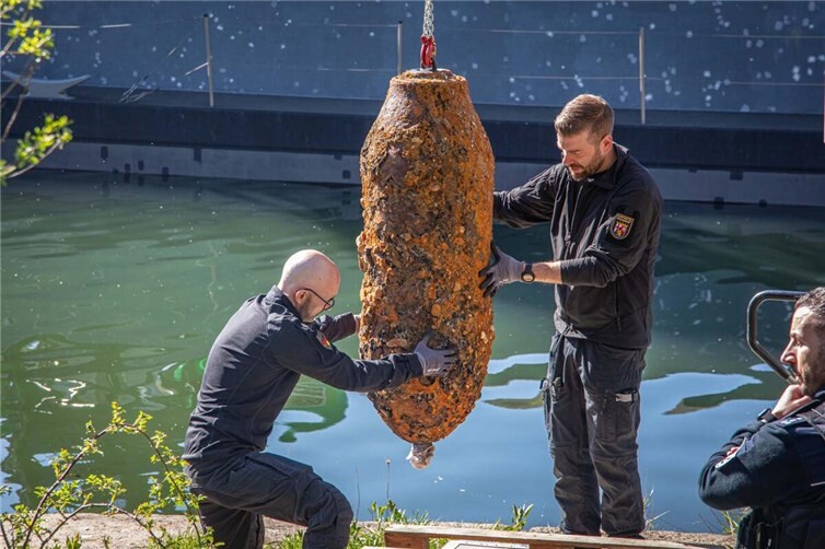 Sascha Hummrich (rechts) und Marco Ofenstein (links) vom Kampfmittelräumdienst Rheinland-Pfalz verluden die Bombe nach der erfolgreichen Entschärfung vom Baggerschiff an Land. 