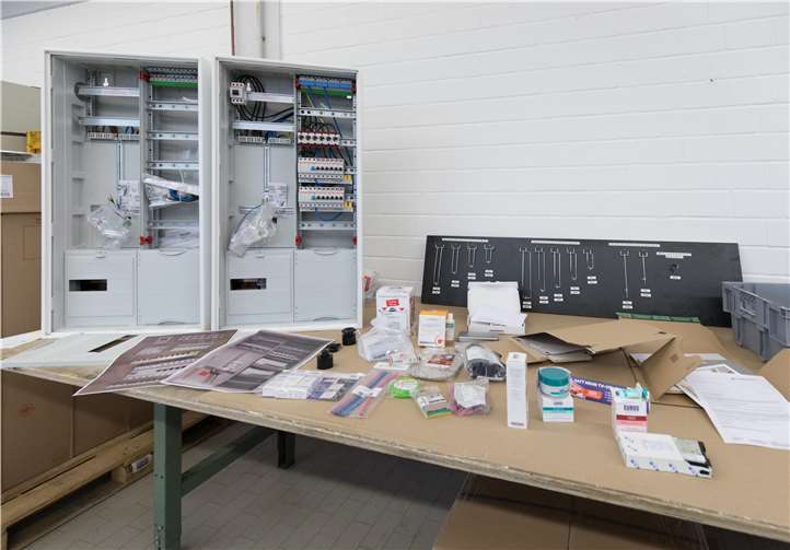 Schaltschränke und Kleinverpackungen werden in der Werkstatt zusammengestellt.