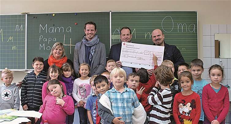 Scheckübergabe in einem der Klassenzimmer der Grundschule Wallersheim. Nicole Adams (Schulleiterin), Philipp Hofmann (Sänger), Kay Wäninger (Gebietsleiter von Ernsting`s Family) und Arthur Horváth (Projektpate) (v.l.).
