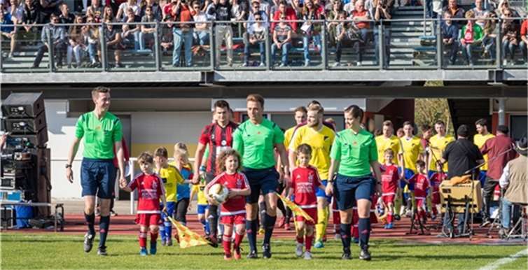 Schiedsrichter Fabian Schneider beim Einlaufen mit Gespann und Mannschaften beim Derby zwischen den Lokalrivalen Ahrweiler und Dernau.©Andreas Ennenbach