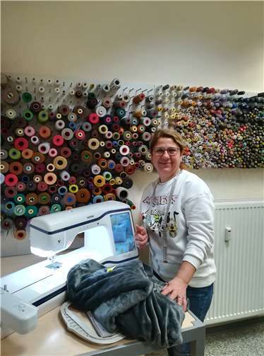 Schneiderin Leyla Demir von der Änderungsschneiderei Leyla in Mayen bestickt alle Decken mit den Initialen der Kinder. So können die personalisierten Kuscheldecken nicht vertauscht erden.Foto: Caritas