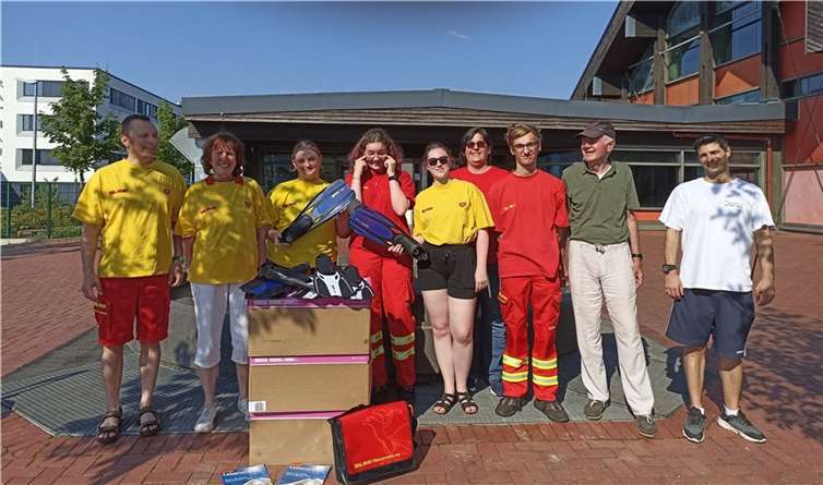 Schnell im Einsatz: Fördervereinsvorsitzender Reinhold Poloczek (zweiter von rechts, neben ihm Hallenbad-Mitarbeiter Jangiz Eisso) überreichte neue Schwimmflossen an die DLRG. Links im Bild DLRG-Gruppenleiter Andreas Schicke.  Foto: privat
