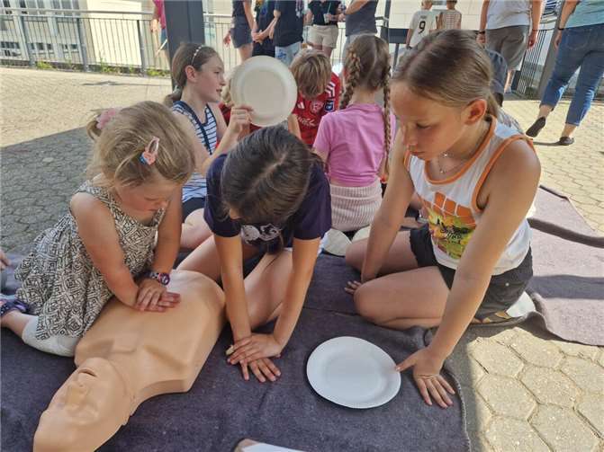 Schon die Kleinsten lernten auf dem Schulhof der Realschule plus, wie eine Herzdruckmassage gelingt. Foto: Martin Schmitt