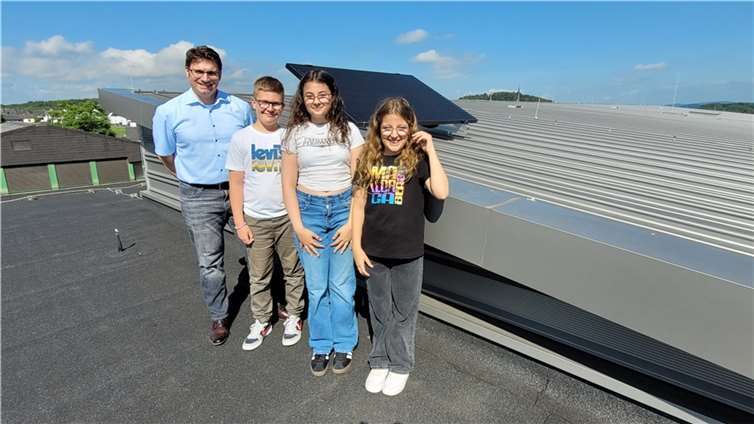Schon in der Schule lernen, wie nachhaltige Energie produziert werden kann: Schulleiter Stephan Szasz (l.) integriert das neue Balkonkraftwerk gleich in mehrere Unterrichtsfächer. Mika, Alina und Emila (v.l.) der Klasse 5a sind gespannt, wie viel Energie die Anlage auf dem Dach der Freiherr-vom-Stein Schule produziert.