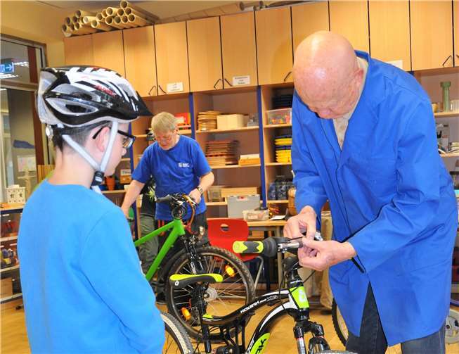 Schüler Constantin Hecke (l.) lässt sein Rad vom Technik-Experten Winfried Tesch prüfen, im Hintergrund Wolfgang Unterbusch.