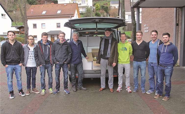 Schüler der Oberstufe übergeben Dieter Trojahn und Horst Sand die mit Lebensmitteln gefüllten schweren Kartons. privat