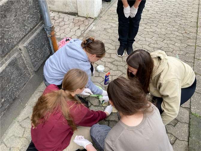 Schüler polieren die Stolpersteine in Mendig.