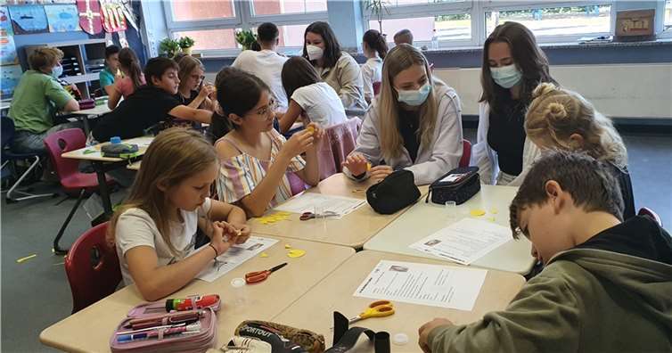 Schülerinnen und Schüler der Klassen 4a und 4b überlegten zunächst in Kleingruppen unter Anleitung von Schülerinnen und Schülern aus verschiedenen MINT-Leistungskursen, wie man ein Raketen-Modell aus Filmdöschen bauen kann. Quelle: Werner-Heisenberg-Gymnasium