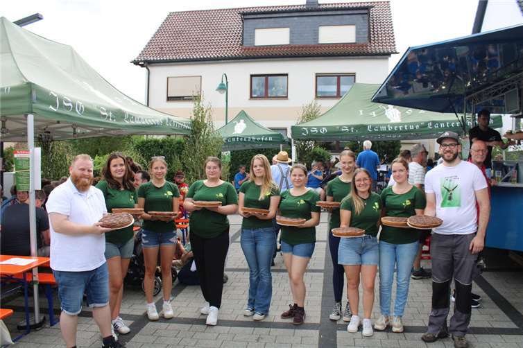 Schützenkönig Florian Scholl (links) und Junngesellen-Schützen-Hauptmann Clemens Queckenberg (rechts) gemeinsam mit den Lantershofener Brötchesmädchen und dem Kult-Kuchen „Maubich“.