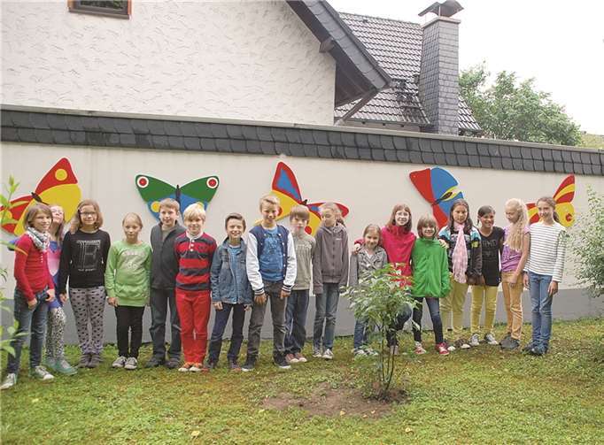 Schulkinder dekorierten die Wand zum Anwesen Kranz mit bunten Schmetterlingen.