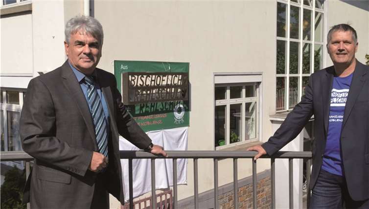 Schulleiter Dirk Johann (rechts) und Albrecht Adam, Leiter des Arbeitsbereichs kirchliche Schulen im Bischöflichen Generalvikariat des Bistums Trier, präsentierten das neue Namensschild der St. Franziskus-Schule.privat