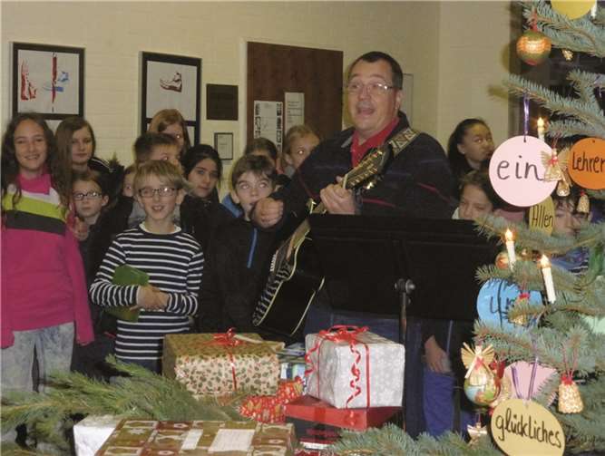 Schulleiter Hans-Georg Meier eröffnet mit Gitarrenspiel und Gesang die Teilnahme des Eichendorff-Gymnasiums an der Weihnachtspäckchenaktion der Organisation „Kinderzukunft“. Hansjörg Schütz