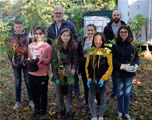 Schulleiter Helmut Zender (hinten links), Lars Gehendes (hinten rechts) vom städtischen Bauamt und Mitglied der Netzwerk-Innenstadt-AG „Öffentlicher Raum“, sowie einige fleißige Nachwuchsgärtner bestücken den neuen Schulgarten des RWG.Foto: privat