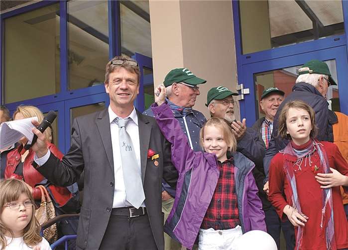 Schulleiter Klaus Mührel gratuliert Hannah Hallmanseder, der Siegerin des Maskottchenwettbewerbs rund um den Drachen ALOGA. ROB