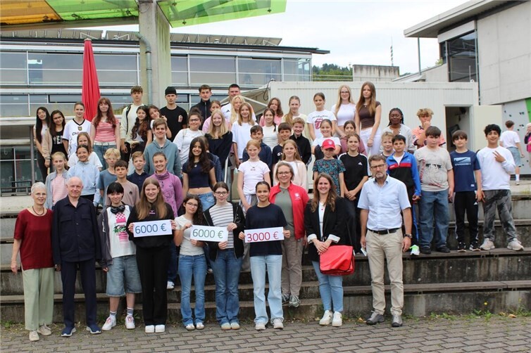 Schulleiter Lutz Hasbach (rechts) freut sich mit den Organisatoren, den beteiligten Schülerinnen und Schülern, sowie den Spendenempfängern über das gelungene Weihnachtsmarktprojekt.