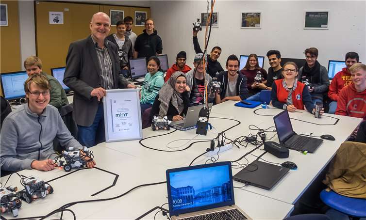Schulleiter Rainer Probst freut sich zusammen mit den Schülern des Beruflichen Gymnasiums Informationstechnik über die Verleihung des Preises MINT-freundliche Schule