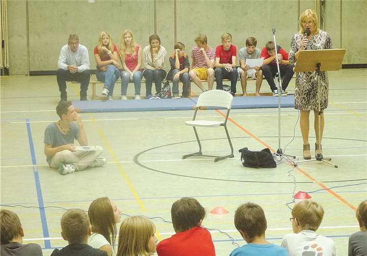 Schulleiterin Lisa Schneider begrüßt die neuen 5. Klassen und deren Familien in der festlich geschmückten Halle.