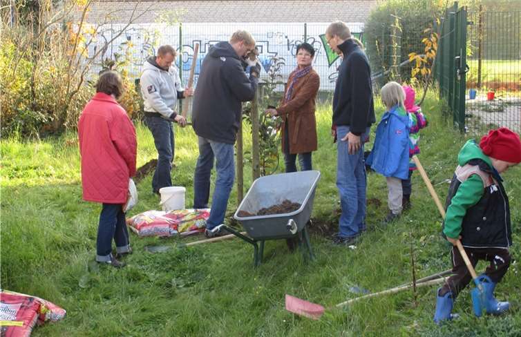 Schulleiterin Orth ließ es sich nicht nehmen, dazu beizutragen, dass die neuen Schützlinge beim Einpflanzen Haltung bewahrten. Die Kinder nutzten derweil die Möglichkeit, die neuen Spielgeräte auszuprobieren.privat
