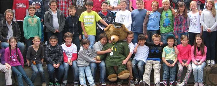 Schutzbär Bulli inmitten seiner Freunde: Abschlussfoto nach Durchführung des Präventionsprojektes „Schutzbär Bulli“ an der Grundschule St. Martin in Remagen (2012).