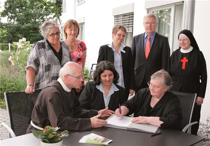 Schwester Marianne Meyer, die Vertreterin der Marienhaus Unternehmensgruppe (vordere Reihe rechts), die weiteren Vertreter des Trägers des Ambulanten Hospizes Neuwied und Mechtilde Neuendorff, die Leiterin des Heinrich Haus Seniorenzentrums, (vordere Reihe Mitte) besiegeln die gute Kooperation mit ihren Unterschriften unter dem Vertrag. as