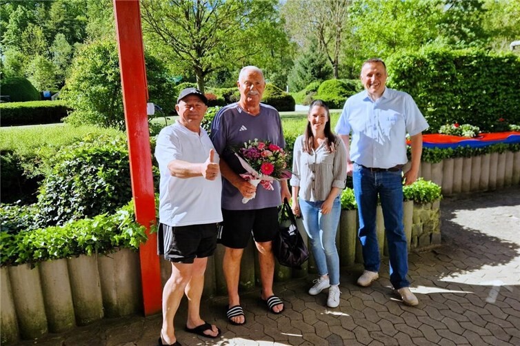 Schwimmmeister Frank von Schmidt, Daniela Friedrichs und Peter Wilkes begrüßen Hans-Werner Müller aus Ochtendung (2.v.l.) als ersten Badegast der Saison mit einem Blumenstrauß